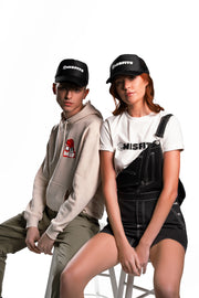 Misfits Gaming logo embroidered in white on a black trucker cap ona male and female model